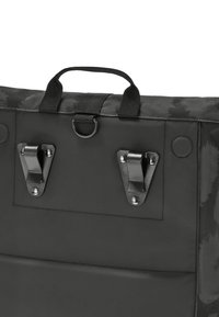 Čierna látková taška s textúrovaným dizajnom, so zachytením dvoch kovových klipsov, rukoväťou a kruhovou pripevňovacou okrúhle na vrchu.