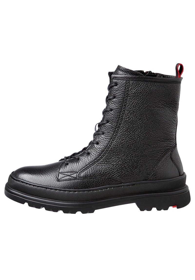 Bottine noire en cuir avec finition texturée, lacets à l'avant, col rembourré et accent rouge contrastant sur la languette et la semelle extérieure.