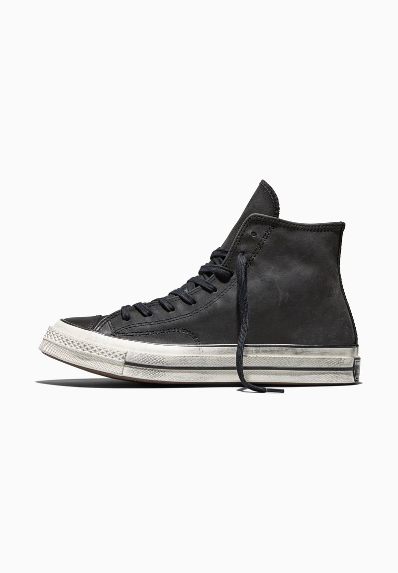 Black high-top sneaker with white rubber sole and black laces, shown from the side on a white background.