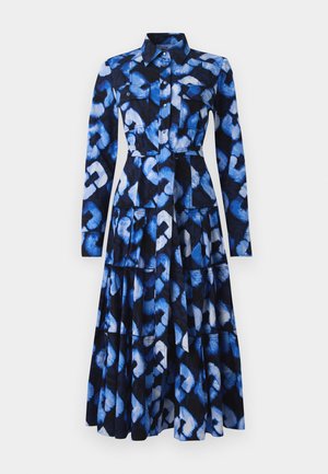 Robe bleue à manches longues, col, fermeture à boutons sur le devant, et tissu à motifs présentant des nuances de bleu et de noir, avec deux poches poitrine.