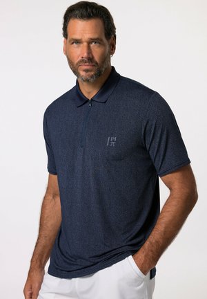 Camisa polo azul marino con un sutil patrón texturizado, mangas cortas, cuello con cremallera y un pequeño logo en el lado izquierdo del pecho. Fabricada en un tejido ligero.