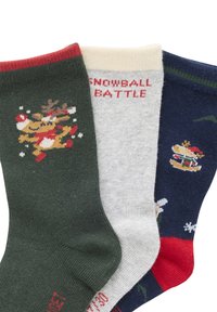 Drei Paar festliche Socken: dunkelgrün mit Rentieren, hellgrau mit dem Text "SCHNEEBALLSCHLACHT" und marineblau mit einem Burgerdesign und roten Akzenten.