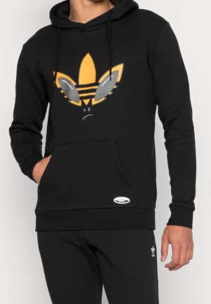 Sudadera negra de algodón, con un gráfico vibrante en naranja de un logotipo estilizado con acentos grises. Incluye un bolsillo tipo canguro en la parte delantera.