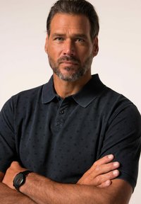 Tmavě modré polo tričko s jemným puntíkovým vzorem, vyrobené z texturované látky, s límečkem a dvouknoflíkovým zapínáním.