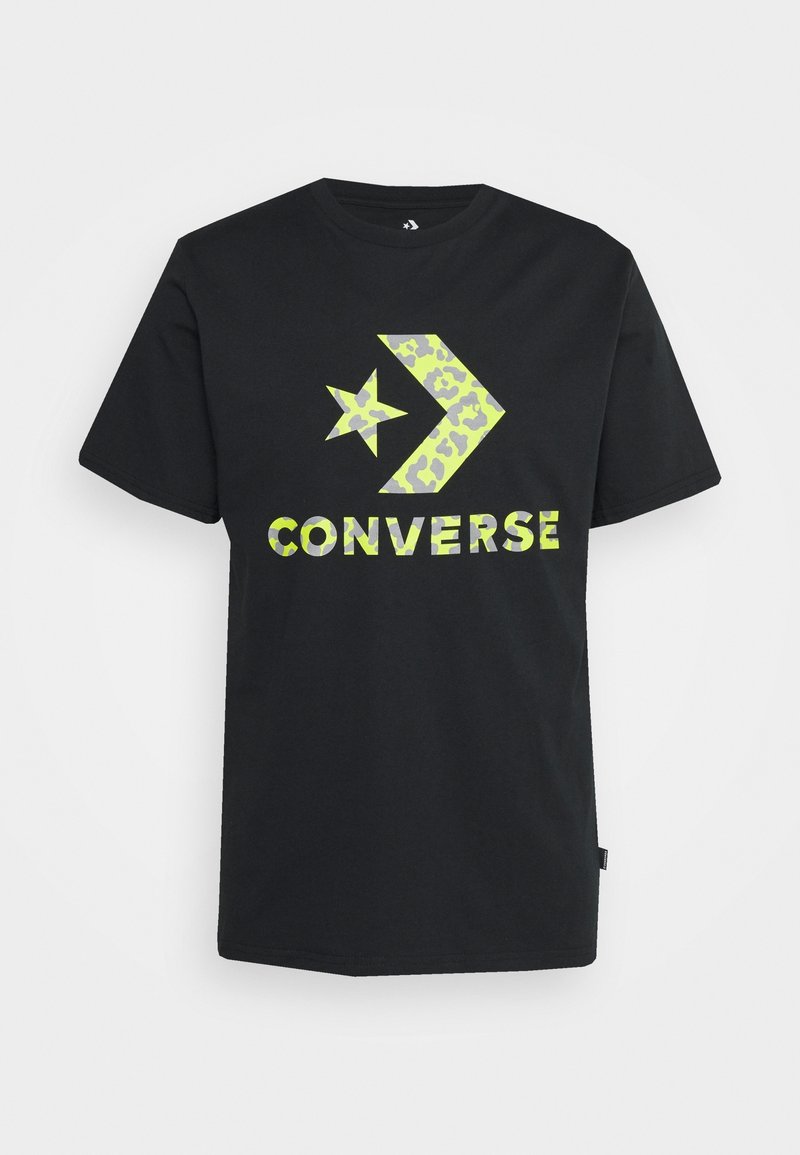 T-shirt noir à manches courtes avec étoile camouflée jaune-vert fluo et logo flèche au-dessus du mot "CONVERSE" en impression assortie.