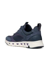 Sneaker blu navy con una combinazione di pelle liscia e camoscio, con una suola bianca texturizzata e dettagli viola vicino al tallone.