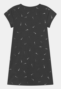 Czarna szara sukienka z bawełny z krótkimi rękawami, zdobiona rozproszonym wzorem białego i jasnoszarego logo Nike. Okrągły dekolt.