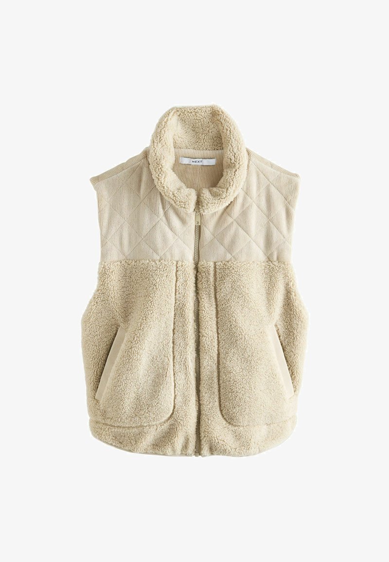 Beige vest featuring a quilted corduroy upper and soft faux fur lower. High collar and two front pockets. Zipper closure in the center.