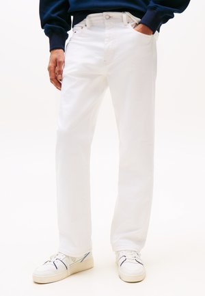 White straight-leg jeans made of cotton denim, featuring a classic five-pocket design and metal button closure. Paired with white sneakers.