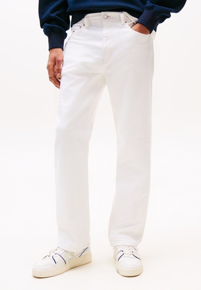 Jeans droits blancs en denim de coton, dotés d'un design classique à cinq poches et d'un bouton en métal. Associés à des baskets blanches.
