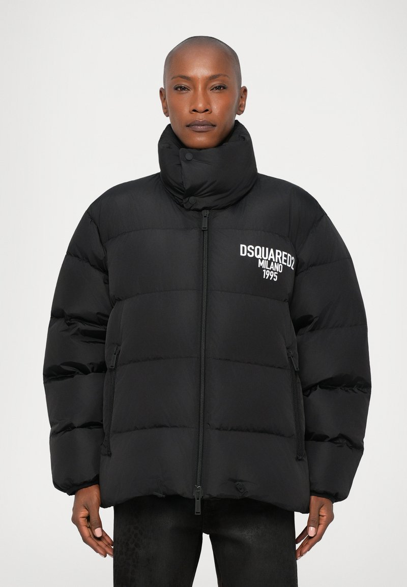 Zwarte pufferjack met hoge kraag, ritssluiting en zijzakken. Bevat het "DSQUARED2 MILANO 1995" logo in het wit op de borst.