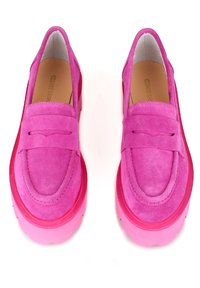 Ett par klarröda mockaloafers med chunky sulor och pennyremmar, sedda ovanifrån på vit bakgrund.