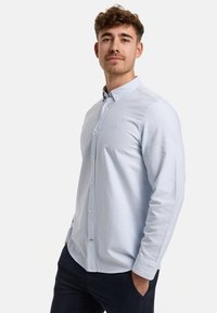 Hellblau-weißer gestreifter Langarmshirt mit Button-Down-Kragen und kleinem Logo auf der Brust, aus weichem Stoff gefertigt.