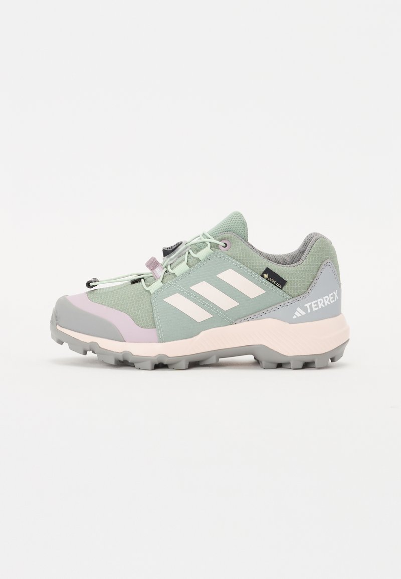 Baskets de sport vert clair avec des accents gris et rose, tige en tissu en mesh, semelle en caoutchouc avec traction et lacets élastiques pour un ajustement réglable.