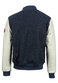 Giacca bomber in misto lana blu navy con maniche in pelle crema e polsini in maglia blu navy. Dettaglio patch rosso sulla manica sinistra. Design pulito e strutturato.
