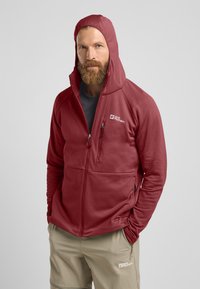 Rode fleece jacket met een hoge kraag en aangehechte capuchon, met een textuurpatroon, ritszakken aan de voorkant en een logo op de borst.