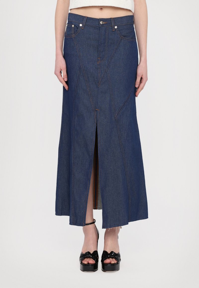 Denim midi-seelik, millel on ees lõhik ja ainulaadne õmbluse detail. Omab tumedat indigo värvi ja kontrastset oranži tikandit.