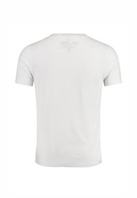 Camiseta blanca de algodón con mangas cortas, cuello redondo y un detalle de etiqueta impresa en la parte superior de la espalda. Textura suave, ajuste clásico.