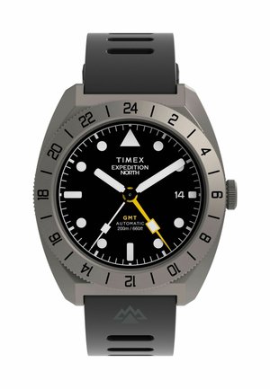 Schwarze Timex Expedition North GMT Uhr mit grauem Rahmen, weißen Stundenmarkierungen, gelbem GMT-Zeiger und grauem Gummiband mit Berglogo.