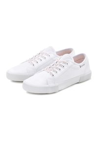 White canvas sneakers with round toe, textured rubber outsole, and matching white laces. Features minimalistic design with subtle branding.