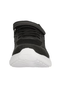 Schwarzer Sportschuh mit strukturiertem Obermaterial, das durch Schnürsenkel und einen Klettverschluss gesichert ist, mit einer weißen Gummi-Außensohle.