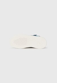 Witte schoenzool met perforaties en een textuurpatroon voor grip, met het "GEOX" merklogo en maatdetails aan de onderkant.