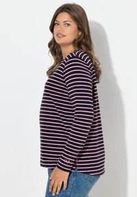 Proužkované tričko s dlouhým rukávem v námořnické modři a růžové barvě, s kulatým výstřihem a bočním rozparkem, vyrobené z lehké látky s měkkou texturou.
