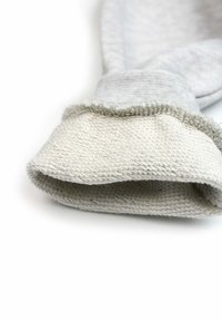 Gant en coton gris avec une manche en tricot gris clair texturé, présentant une surface lisse et un bord supérieur replié pour plus de détails et de style.