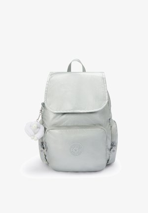 Sac à dos gris clair avec une texture lisse et brillante. Il dispose d'une fermeture à rabat, d'une poche zippée à l'avant, et d'un accent de porte-clés duveteux. Détail de logo circulaire.
