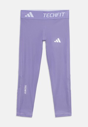 Leggings de compression Adidas Techfit violets avec logos sur la ceinture, la cuisse et le bas de la jambe, posés à plat sur fond blanc.
