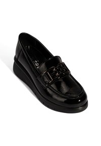 Schwarze Lacklederschuhe mit einem breiten Riemen und metallischem Kettenakzent. Leicht erhöhte Sohle mit strukturiertem Boden für besseren Halt.