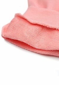 Rozekleurige katoenstof met twee lagen en een gestructureerd oppervlak en ribbelrand, gevouwen aan de bovenrand voor een nette afwerking.