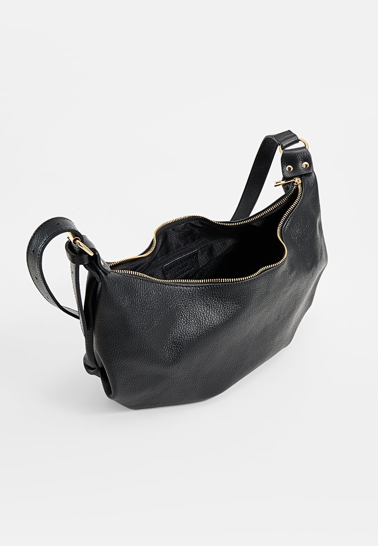 Sac à épaule en cuir noir avec fermeture éclair dorée, bandoulière adjustable et texture grainée, présenté ouvert sur fond blanc.