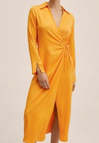 Wickelkleid aus leuchtend orangenem Stoff, mit tiefem V-Ausschnitt, langen Ärmeln und einer Bindung in der Taille; glatte Textur und mittlere Länge.