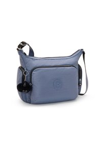 Borsa a tracolla blu in materiale sintetico con tasca con zip, superficie testurizzata, dettaglio del logo rotondo e un charm a pom-pom nero attaccato alla zip.