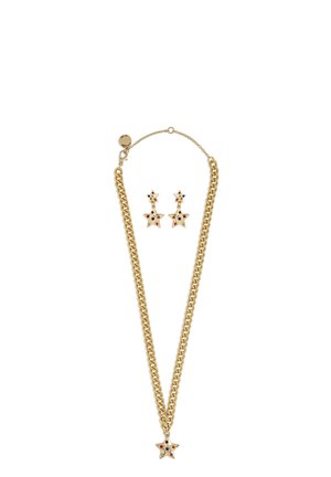 Collier chaîne en or et boucles d'oreilles assorties en forme d'étoile avec des pierres multicolores sur fond blanc.