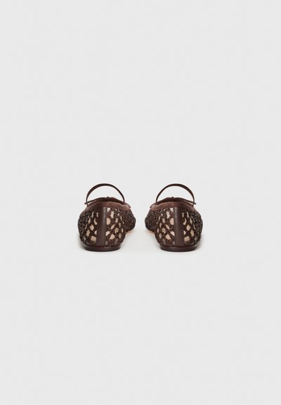 Braune gewebte Slipper mit runder Form, die ein strukturiertes Mesh-Design und braune Lederakzente an der Ferse aufweisen.