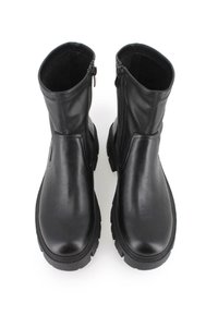 Botas de tobillo de cuero negro con una textura suave, cremalleras laterales, punta redondeada y suelas de goma gruesa para un mejor agarre.