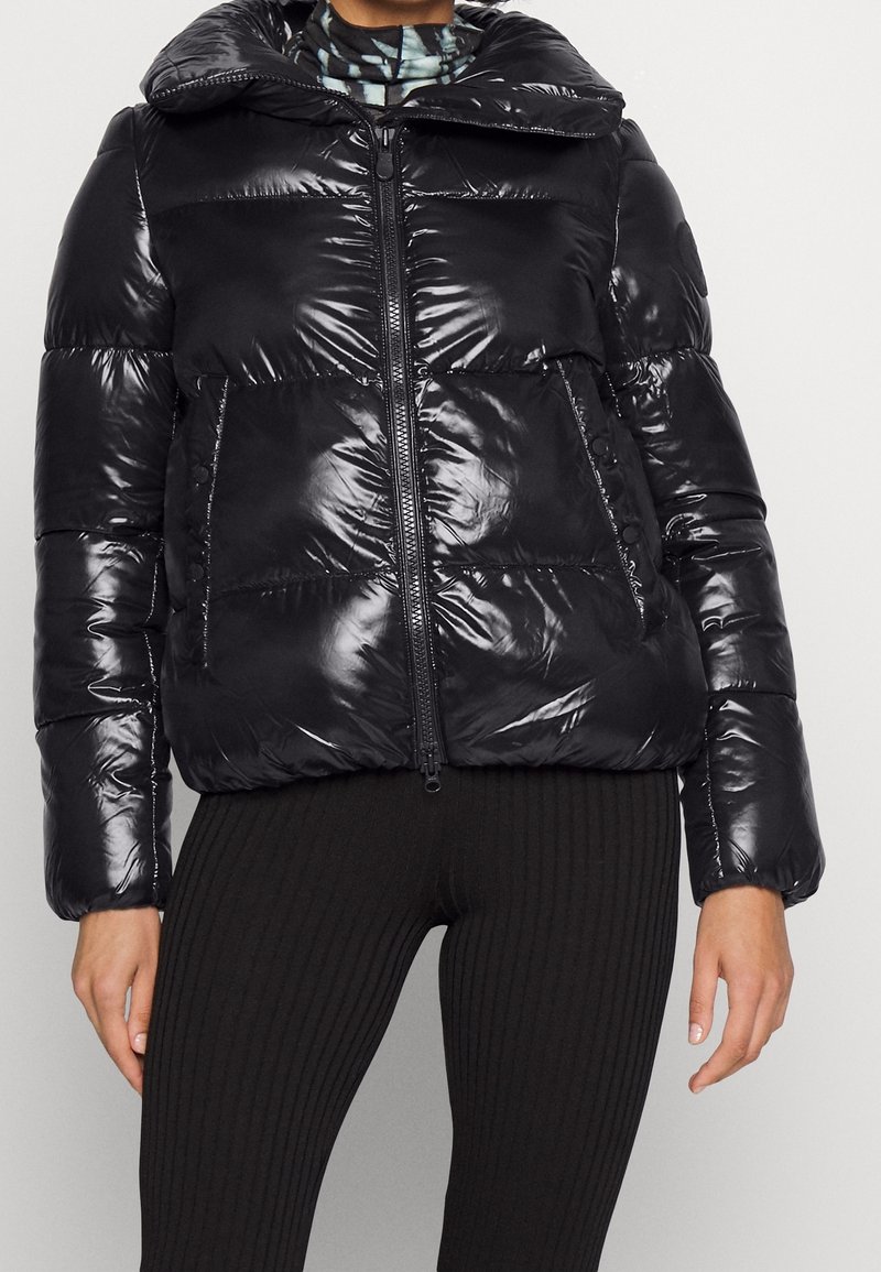 Giubbotto imbottito nero con finitura lucida, colletto oversize, chiusura frontale con zip e due grandi tasche, con polsini e orlo a costine.
