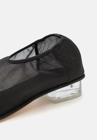 Scarpa nera in rete con punta arrotondata, tacco trasparente a blocco e superficie in tessuto liscio. Presenta un design elegante con un accento trasparente.