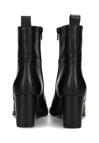 Bottines en cuir noir avec un haut talon bloc, présentant une fermeture éclair sur le côté et une languette à l'arrière pour un enfilage facile. Texture lisse.