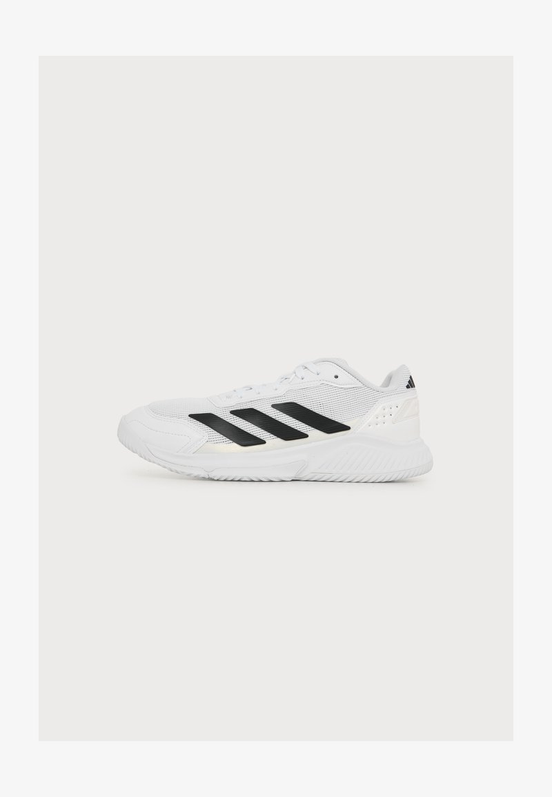 Chaussure de sport blanche avec des bandes noires Adidas, semelle texturée et design à lacets, présentée en profil gauche sur fond blanc.