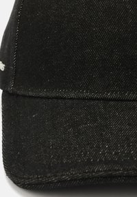 Black denim cap with a structured shape, visible stitching, and a slightly textured surface. Features a curved brim and a minimalist design.