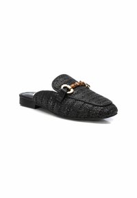 Zapatillas negras tejidas sin cordones con suela plana, que presentan un acento de cadena dorada y marrón, punta redonda y plantilla acolchada para mayor comodidad.
