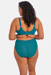 Maillot de bain deux pièces en teal avec un haut de soutien-gorge ajusté à bretelles réglables et un bas taille haute, mettant en avant une texture lisse et un motif minimal.