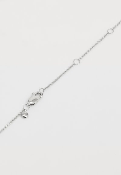 Brăţară din lanţ argintiu, cu un închizător de tip lobster, linkuri circulare şi un farmec mic în formă de scoică. Textură netedă şi design minimalist.