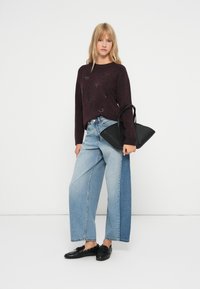 Burgundy knit sweater with textured pattern, light-wash denim wide-leg jeans, and a black angular handbag, paired with black loafers.