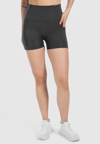 Zwarte high-waisted sportshorts met een zachte textuur, een strakke snit en zijzakken, geschikt voor actieve kleding.