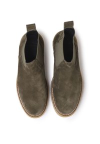Bottes de cheville en suède vert olive avec panneaux latéraux élastiques et languettes de tirage. Semelle en caoutchouc avec un détail de couture blanche le long du bord.