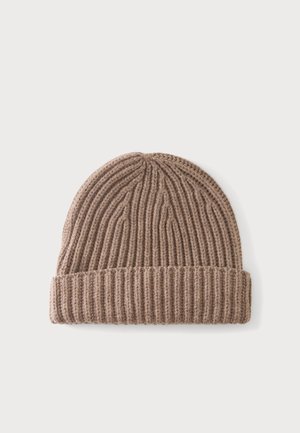 Bonnet tricoté marron clair avec un bord replié, présenté à plat sur un fond clair uni.